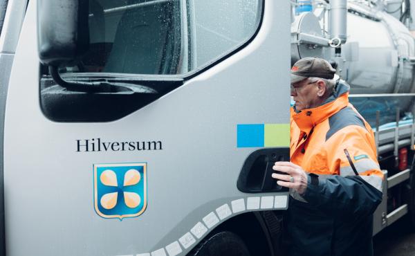 Een medewerker van gemeente Hilversum stapt een vrachtauto in